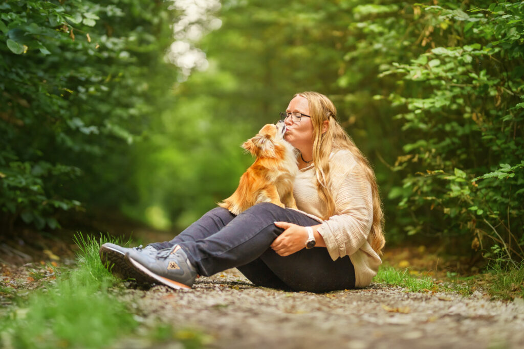 Hund-Mensch-Fotografie: Chihuahua auf Frauchens Schoss im Wald